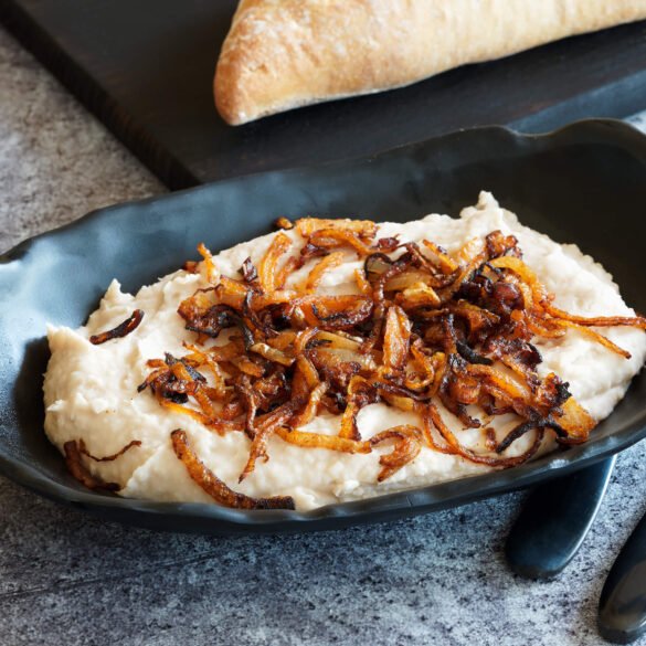 Romanian white bean dip with garlic, vegetable oil, with a topping of sauteed onions and tomato paste