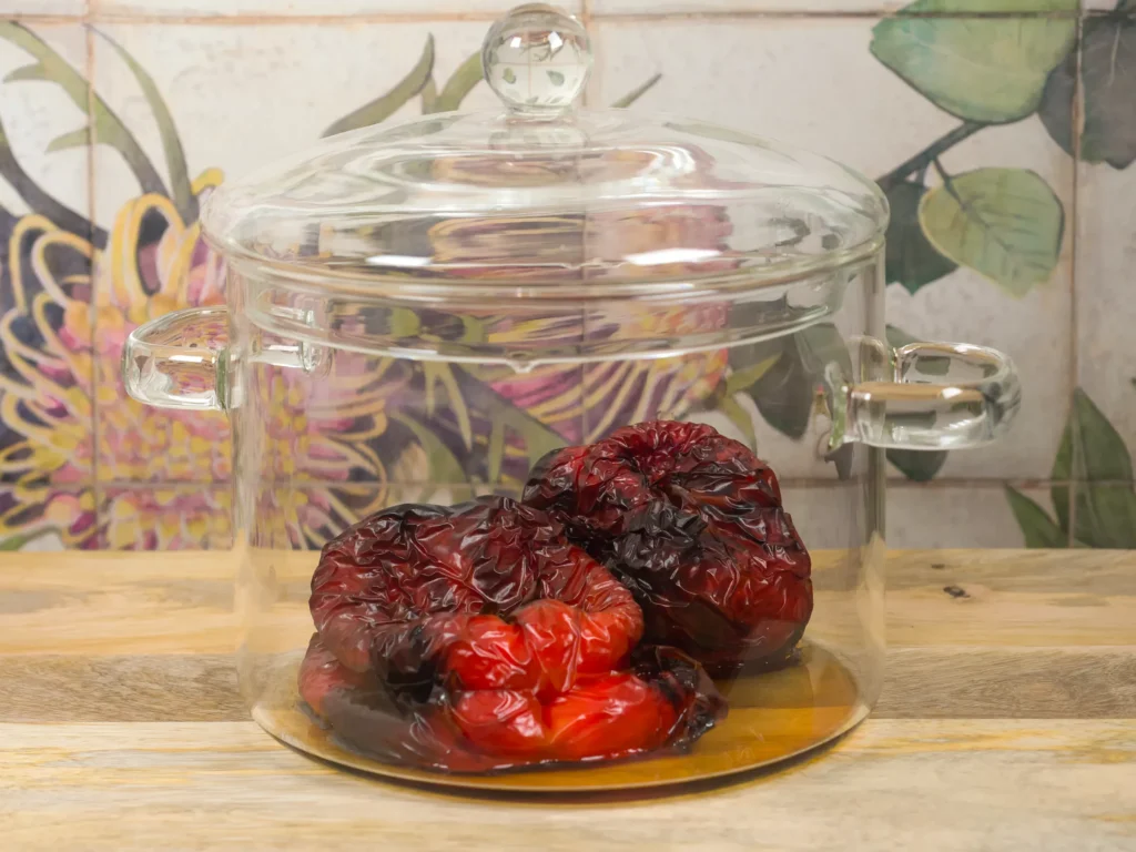 Leave the peppers to cool down. The stream makes the skin easy to remove.